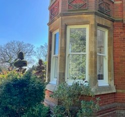 White painted timber sash windows in a curved bay on a Victorian brick property in South West London